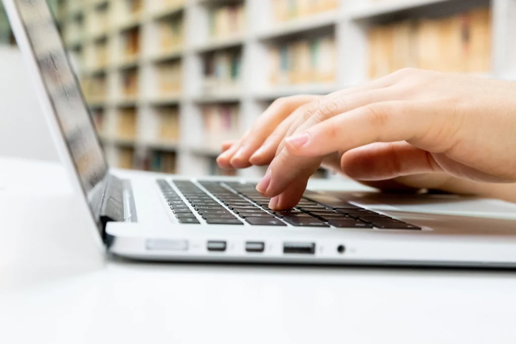 Close up view of someone typing on a laptop